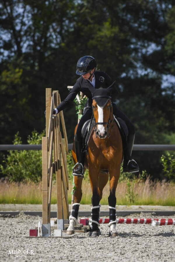 Eine Frau reitet durch eine Gasse.